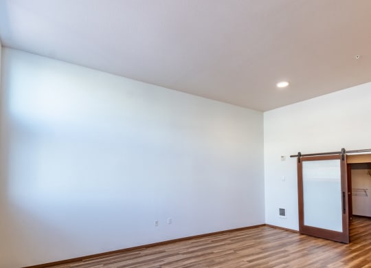 an empty living room with white walls and a sliding glass door
