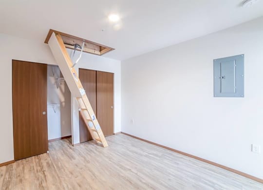 an empty room with a staircase and a wardrobe in it