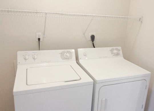 a white washer and dryer in a room with white walls