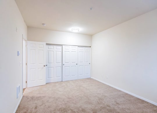 a bedroom with white walls and white doors and carpet