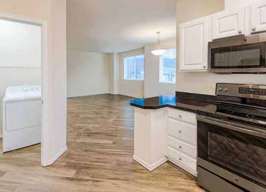 an empty kitchen with a washer and dryer in it