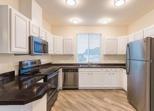a kitchen with stainless steel appliances and white cabinets