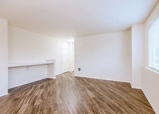 an empty living room with white walls and wood flooring