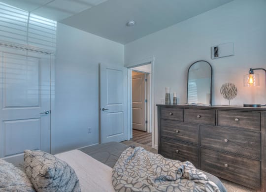 a bedroom with a bed and a dresser with a mirror