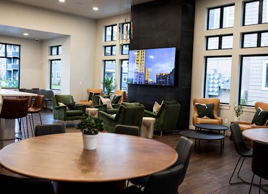A modern living room with a large TV and comfortable seating.