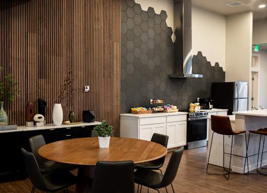 A modern kitchen with a wooden table and chairs.