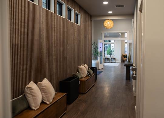 A long hallway with a bench and pillows on it.