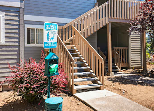 A sign on a pole that says "Pet Vast" is in front of a staircase.