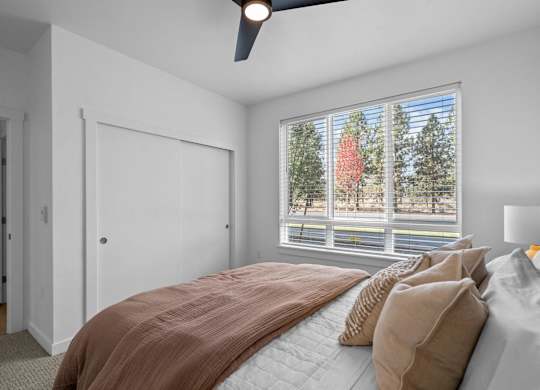 a bedroom with a large window and a bed