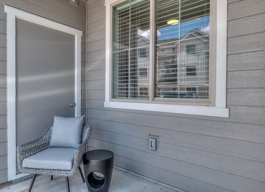 a front porch with a chair and a door with a window