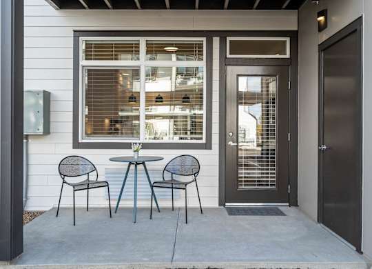 a patio with a table and chairs and a door