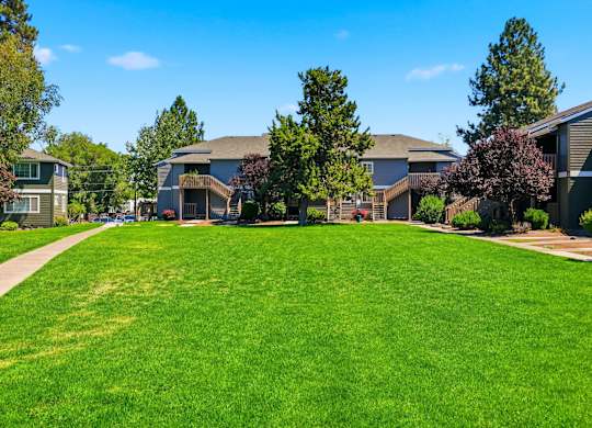 A grassy field with a pathway leading to a building.