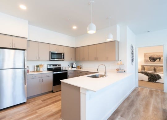 a kitchen with an island and a stainless steel refrigerator