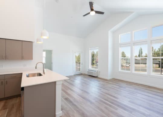 an empty living room and kitchen with a large window