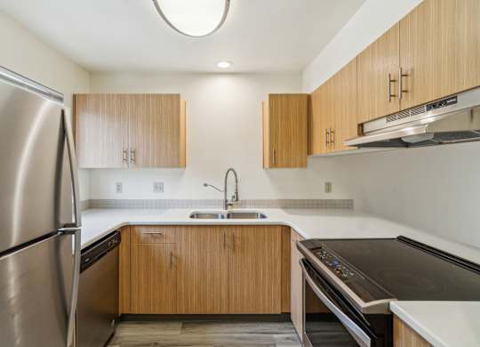 A modern kitchen with wooden cabinets and stainless steel appliances.