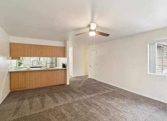 A room with a ceiling fan and carpeted floor.