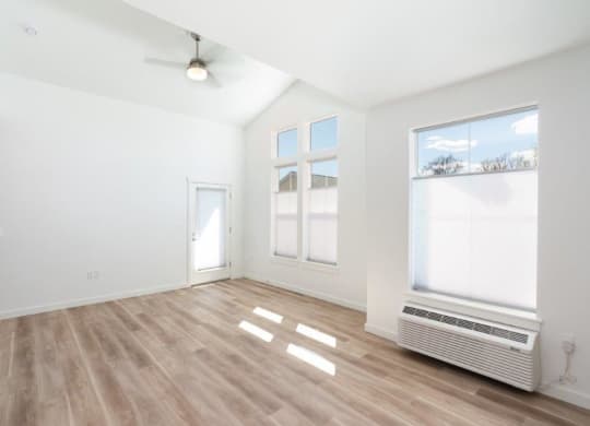an empty living room with a radiator and a window