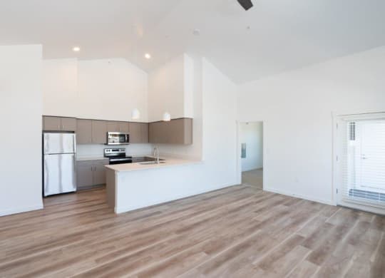 an empty kitchen and living room with white walls and wood floors