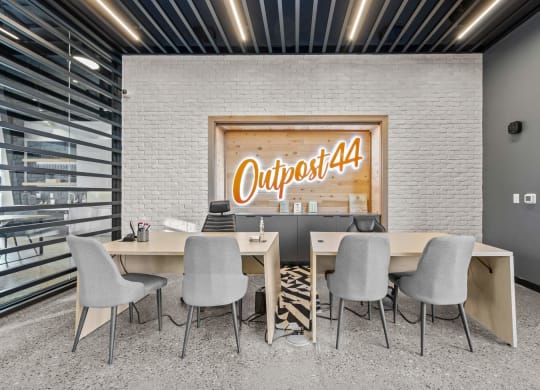 a conference room with tables and chairs and a sign on the wall