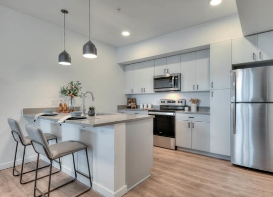 a kitchen with stainless steel appliances and an island with two stools
