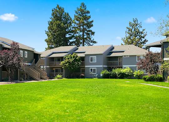 A row of houses with a green lawn in front.