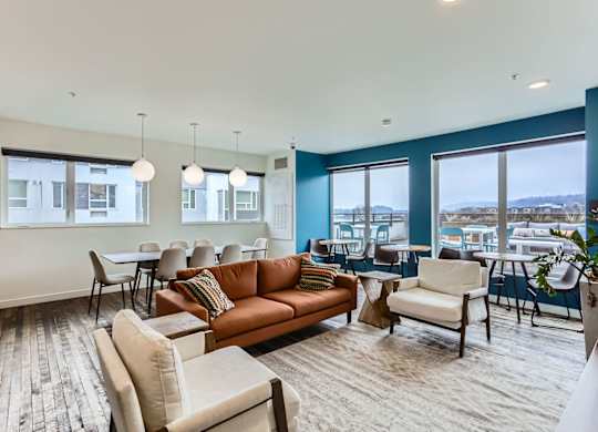 A living room with a couch, chairs, and a dining table.
