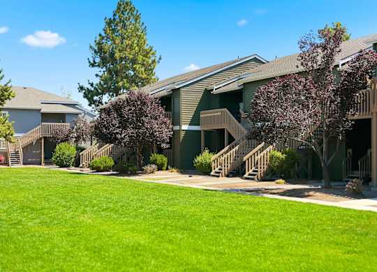 A grassy area in front of apartment buildings.