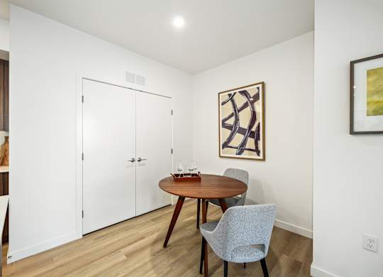 A dining room with a wooden table and chairs.