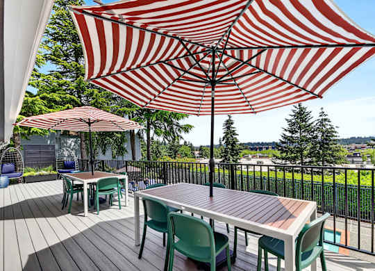 A patio with a table and chairs under a striped umbrella.