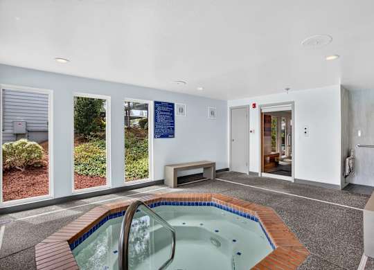 A small indoor swimming pool with a bench.
