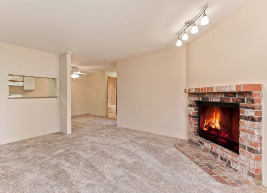 an empty living room with a fireplace and a carpeted floor