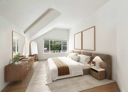 A bedroom with a large bed, nightstands, and a window overlooking a tree-filled yard.