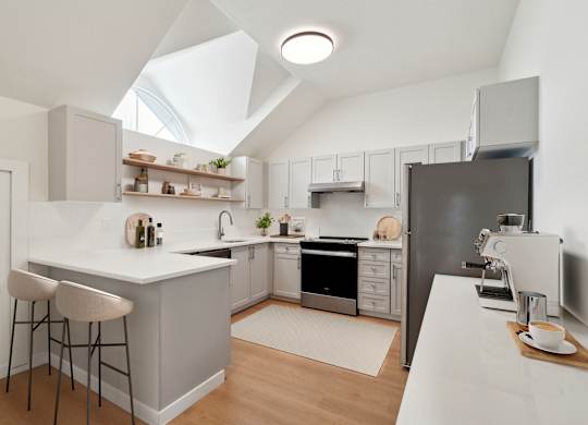 A modern kitchen with a white countertop and a black refrigerator.