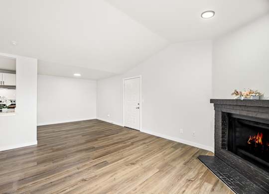 a living room with a fireplace and wooden floors