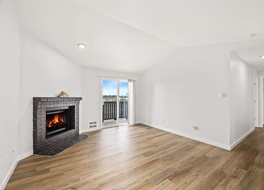 a living room with a fireplace and a door to a balcony