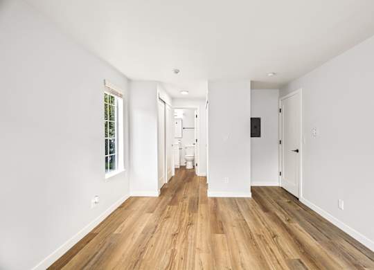 a living room with white walls and a wood floor