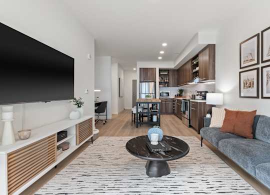 A modern living room with a grey couch and a black coffee table.