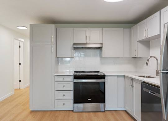 A kitchen with white cabinets and stainless steel appliances.