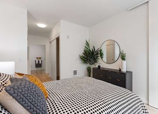 A bedroom with a bed, dresser, and mirror.