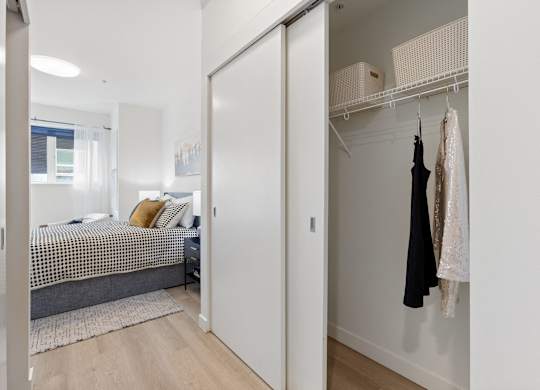 A bedroom with a bed, a wardrobe, and a window.