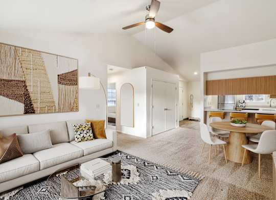 A living room with a white couch and a large painting on the wall.