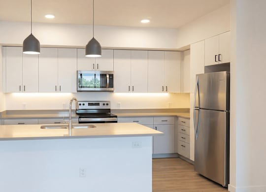 A modern kitchen with stainless steel appliances and white cabinetry.