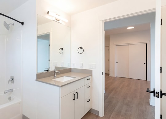 A bathroom with a white tub and sink.