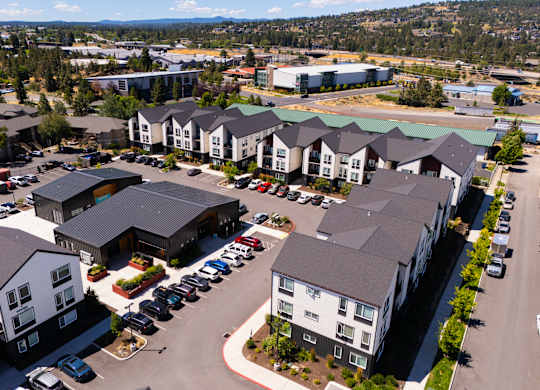 A large parking lot is surrounded by apartment buildings.