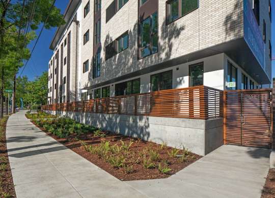 A modern building with a white facade and a wooden fence.