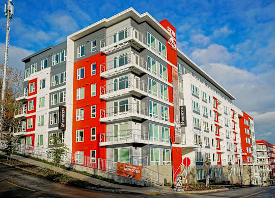 A multi-story building with red and white balconies.
