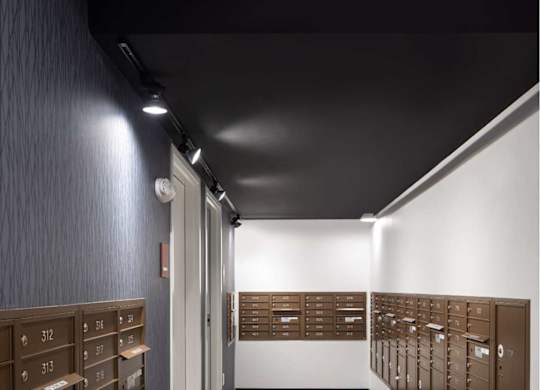 A long hallway with a row of mailboxes on the wall.