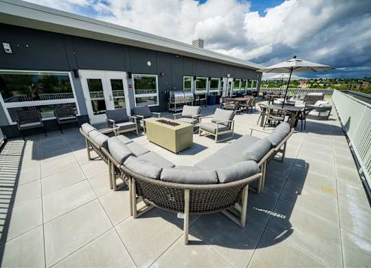 A patio with a table and chairs and a white umbrella.