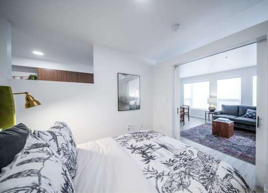 A bedroom with a large bed and a mirror on the wall.