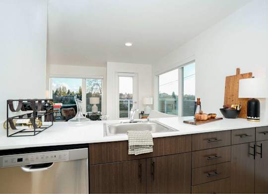 A modern kitchen with dark wood cabinets and a white countertop.